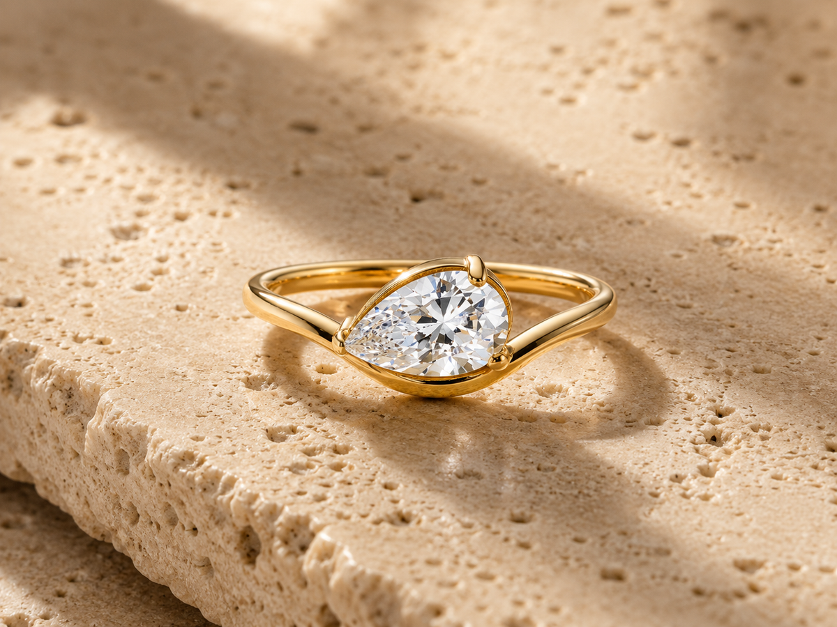 Rosemere Coralie pear-cut solitaire gold ring on natural stone in soft daylight