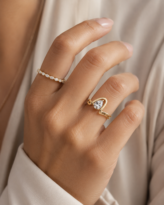 Woman wearing the Rosemere Coralie pear-cut solitaire gold ring, everyday styling