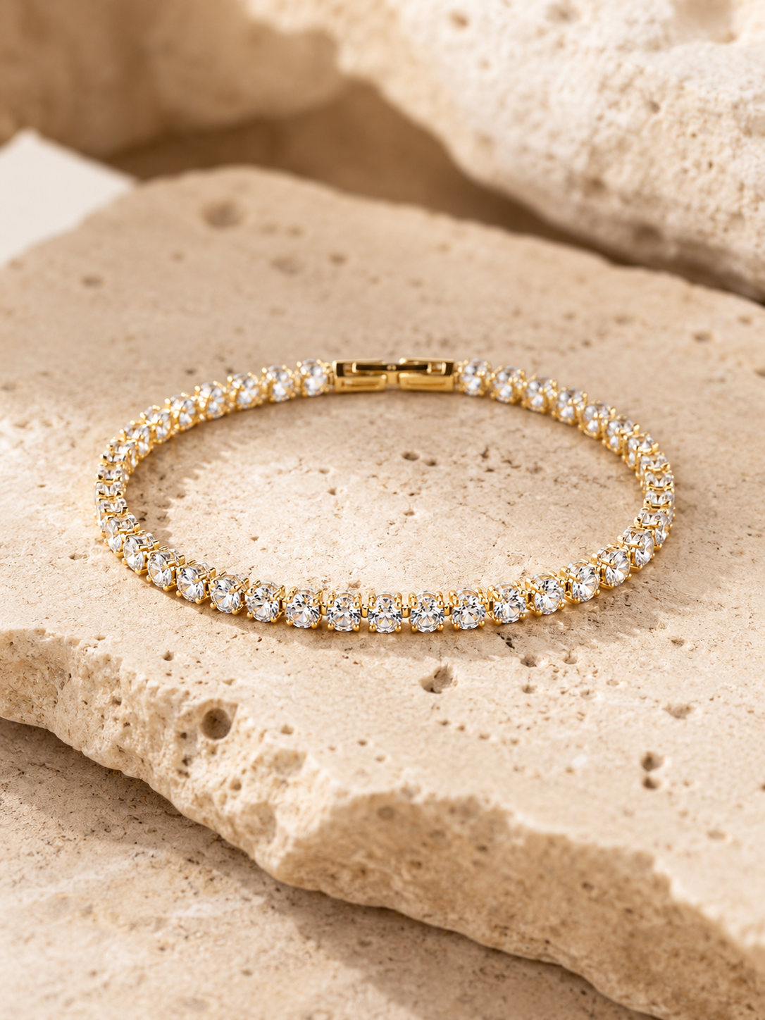 Rosemere Dahlia gold tennis bracelet on natural stone in soft daylight