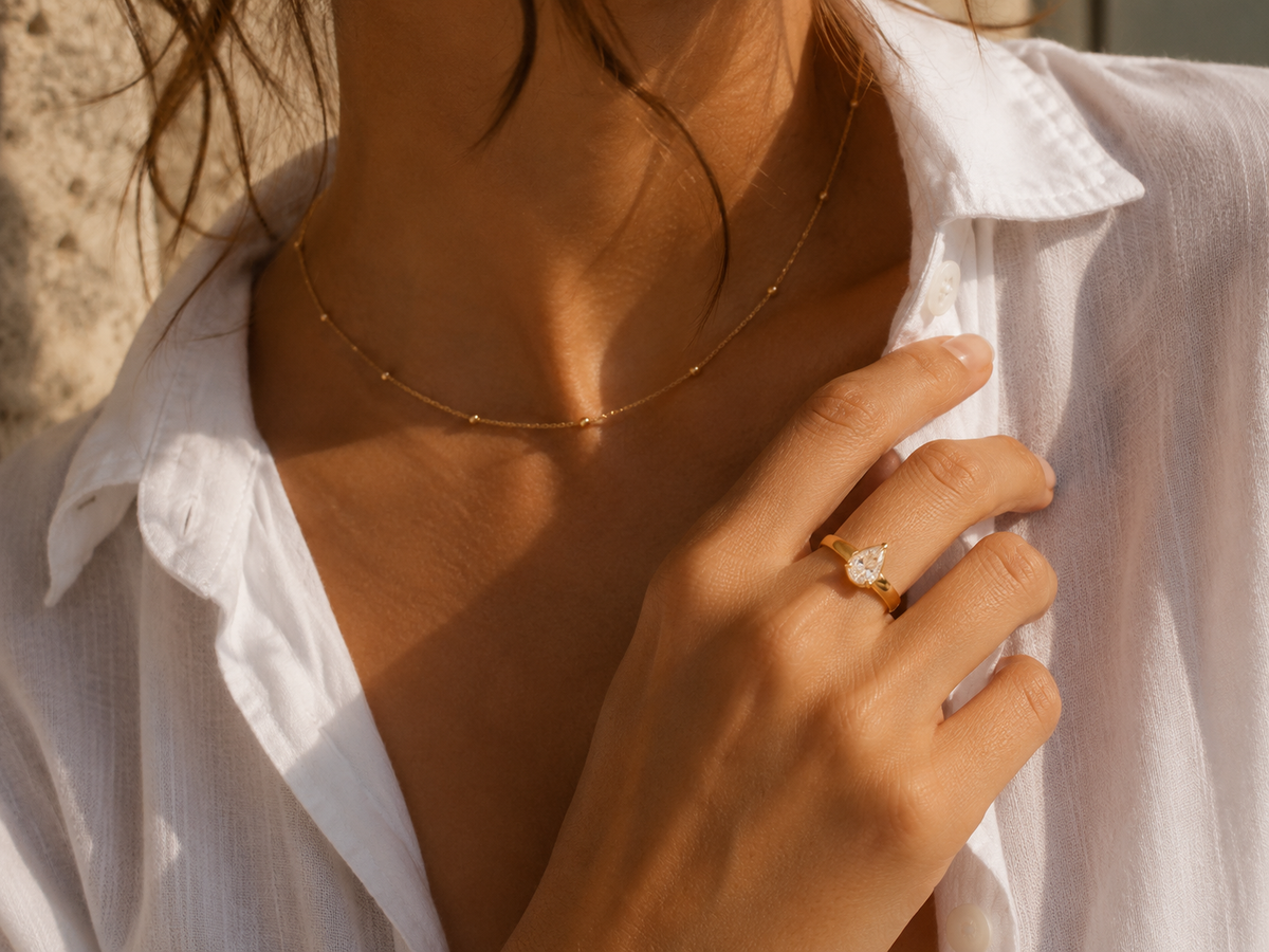 Woman wearing the Rosemere Alessia pear-cut gold ring, everyday styling