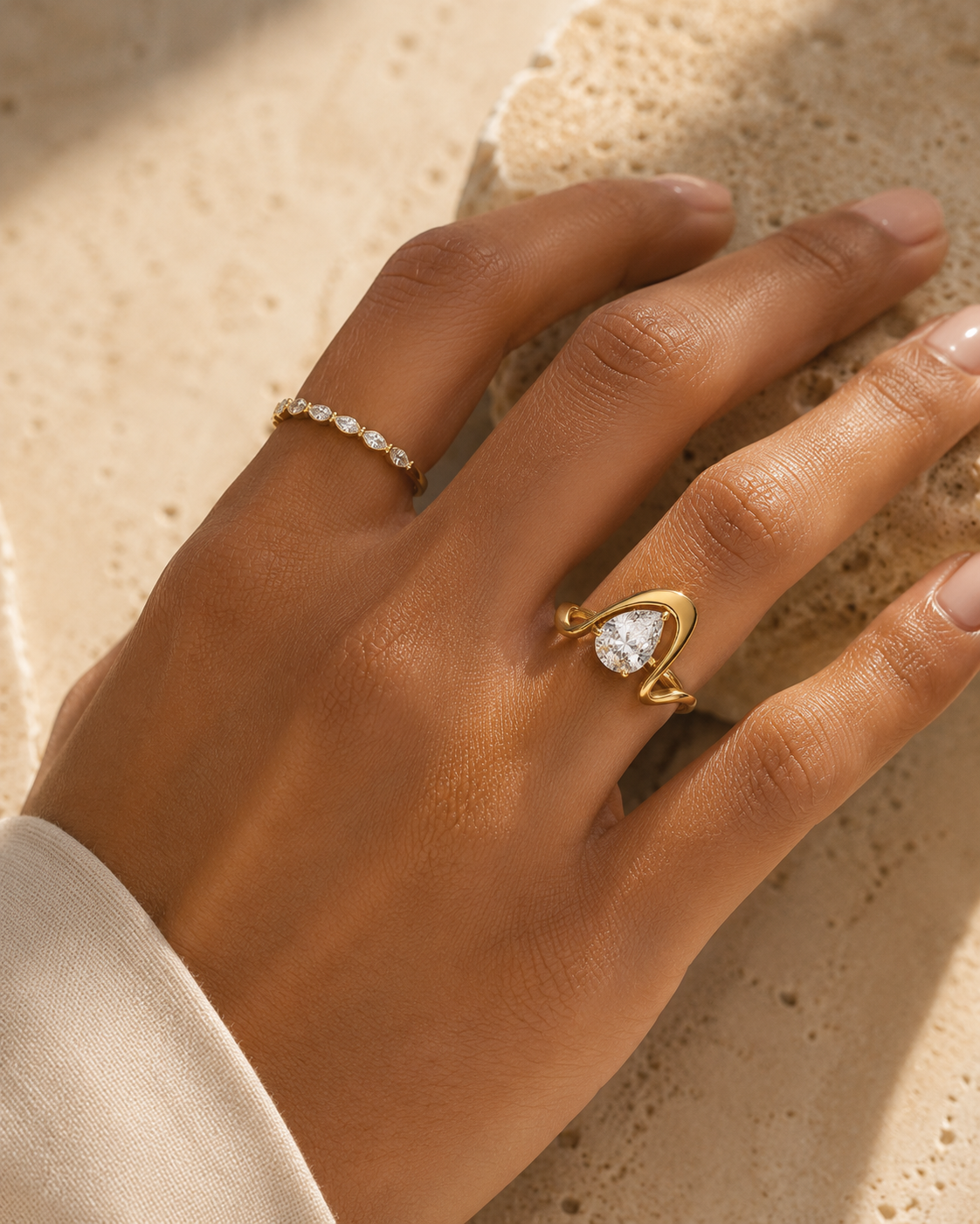 Woman wearing the Rosemere Celeste pear-cut gold ring, everyday styling