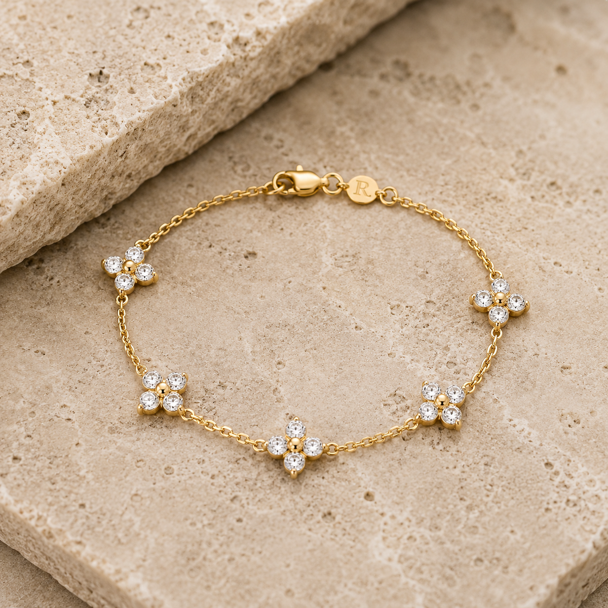 Rosemere Lumi gold clover bracelet on natural stone in soft daylight