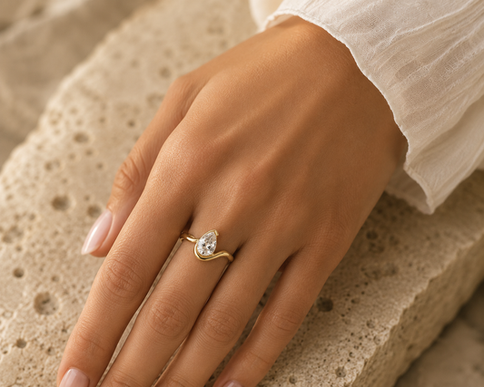 Woman wearing the Rosemere Lyric pear-cut gold ring, everyday styling