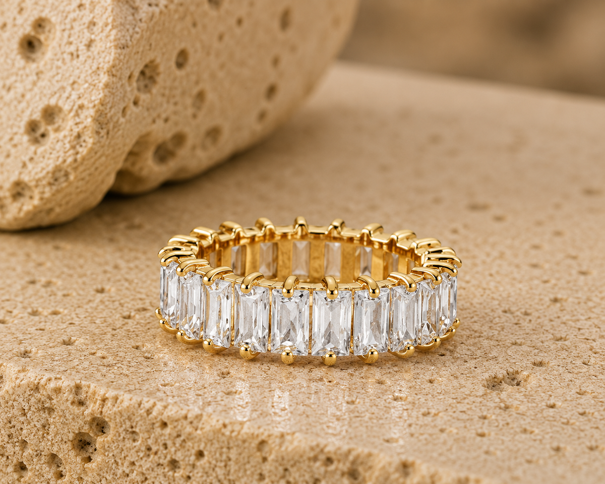 Rosemere Seraphine gold eternity ring on natural stone in soft daylight