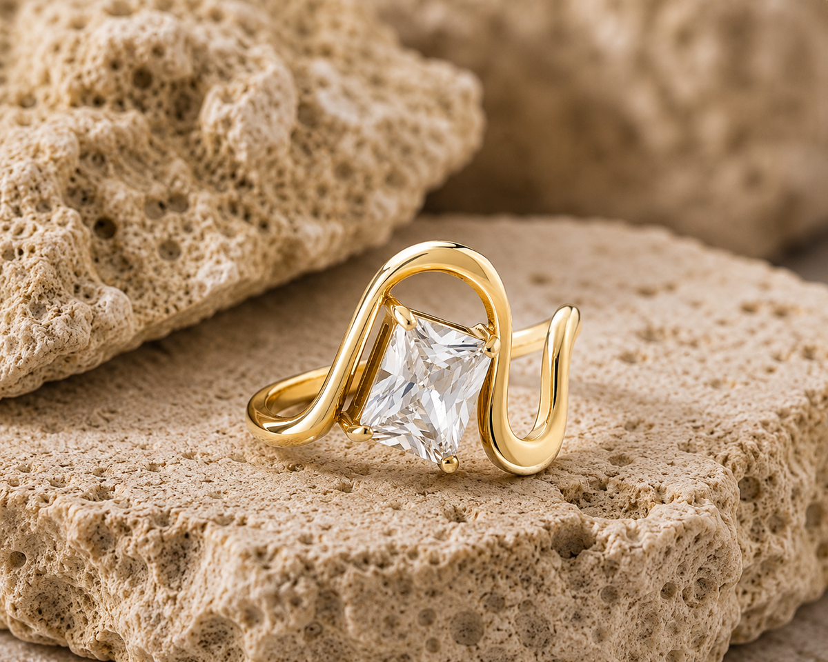Rosemere Sonata emerald-cut gold ring on natural stone in soft daylight