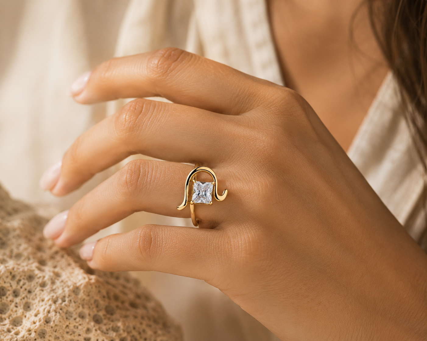 Woman wearing the Rosemere Sonata emerald-cut gold ring, everyday styling